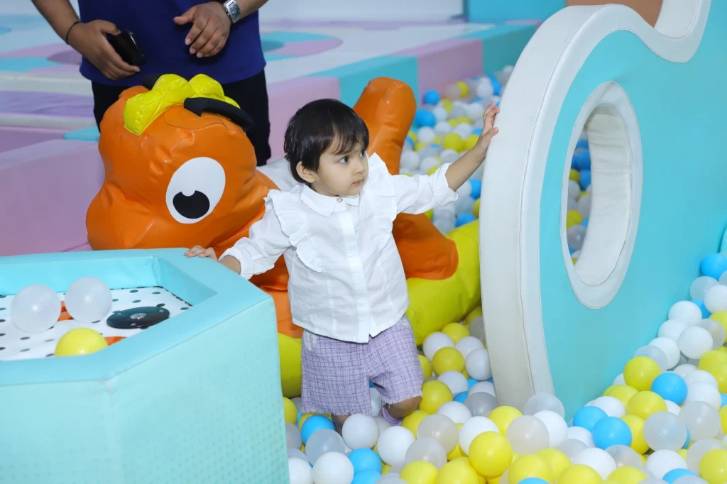 Toddler exploring colourful ball pits to build sensory and motor skills