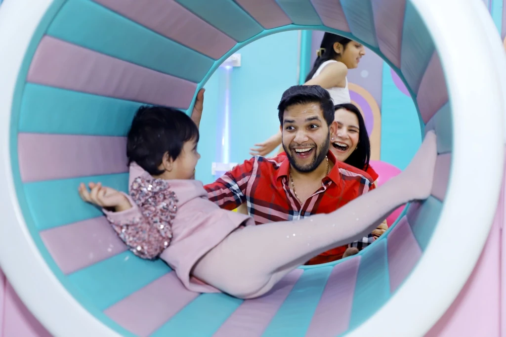 Child enjoying children's indoor slides and active play to build balance and coordination